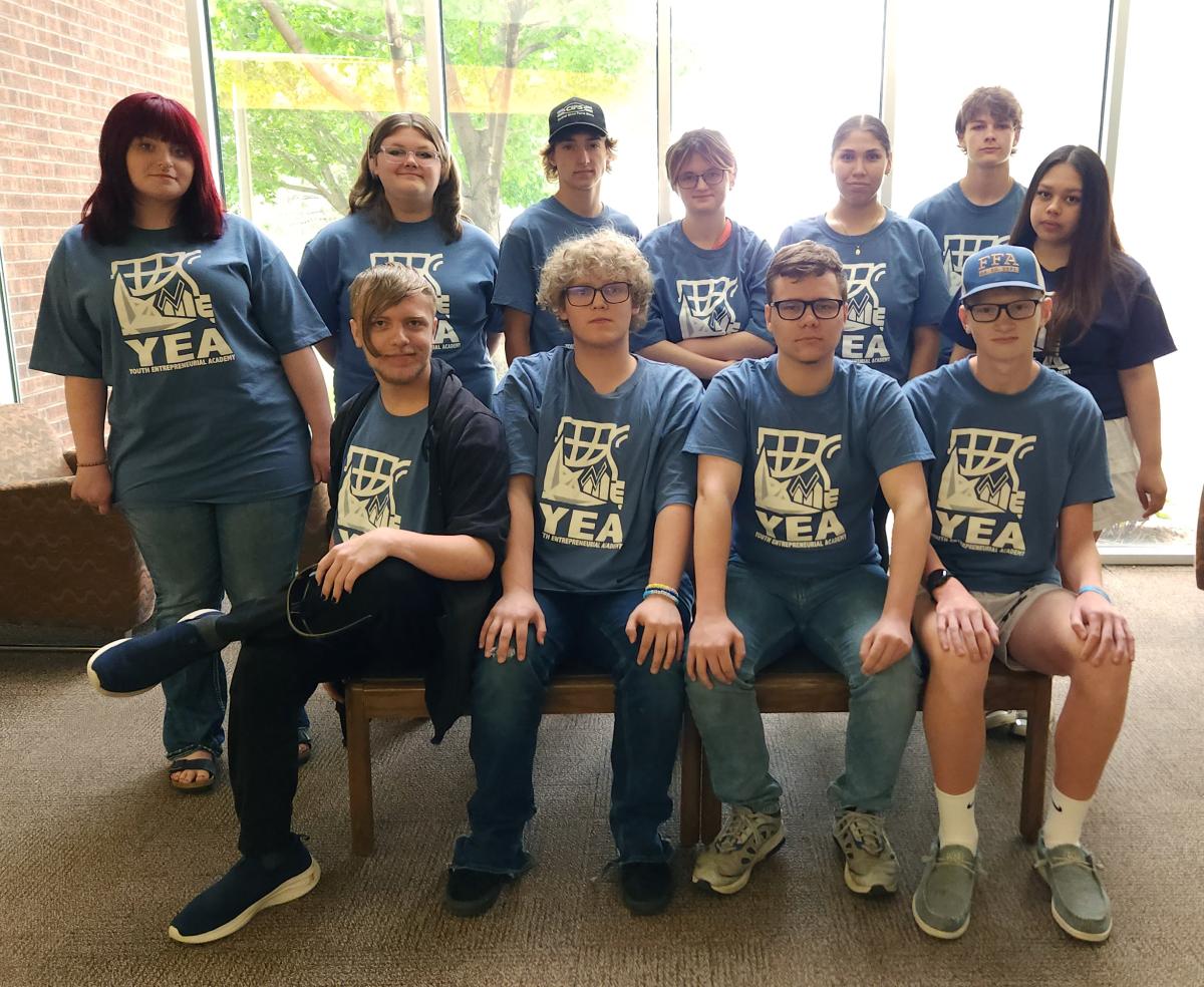 A group of high school students wearing Youth Entrepreneurial Academy shirts